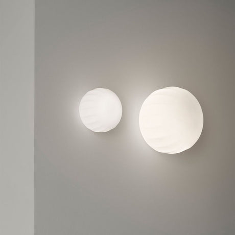 Luceplan Lita Wand- & Deckenlampe Ø 14cm Weiß an einer Wand, dekorative opalene Glas-Lampe.