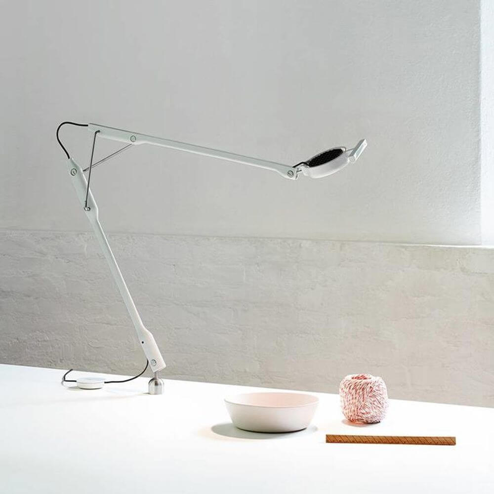 Luceplan Tivedo LED Büro-Tischleuchte 3000K auf einem Tisch mit einer Schüssel und Dekoration.