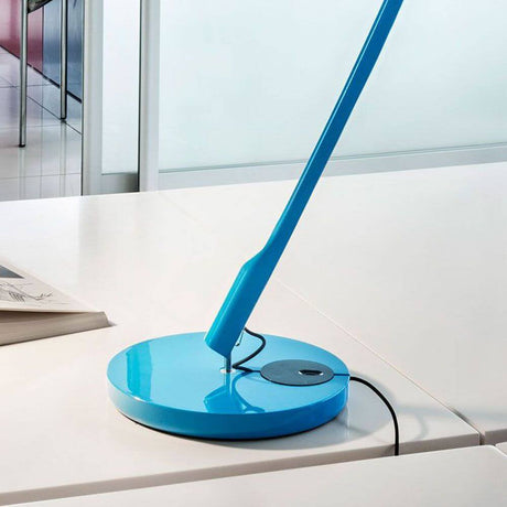 Luceplan Tivedo Tischfuß Ø 19cm in leuchtendem Blau auf modernem Tisch.
