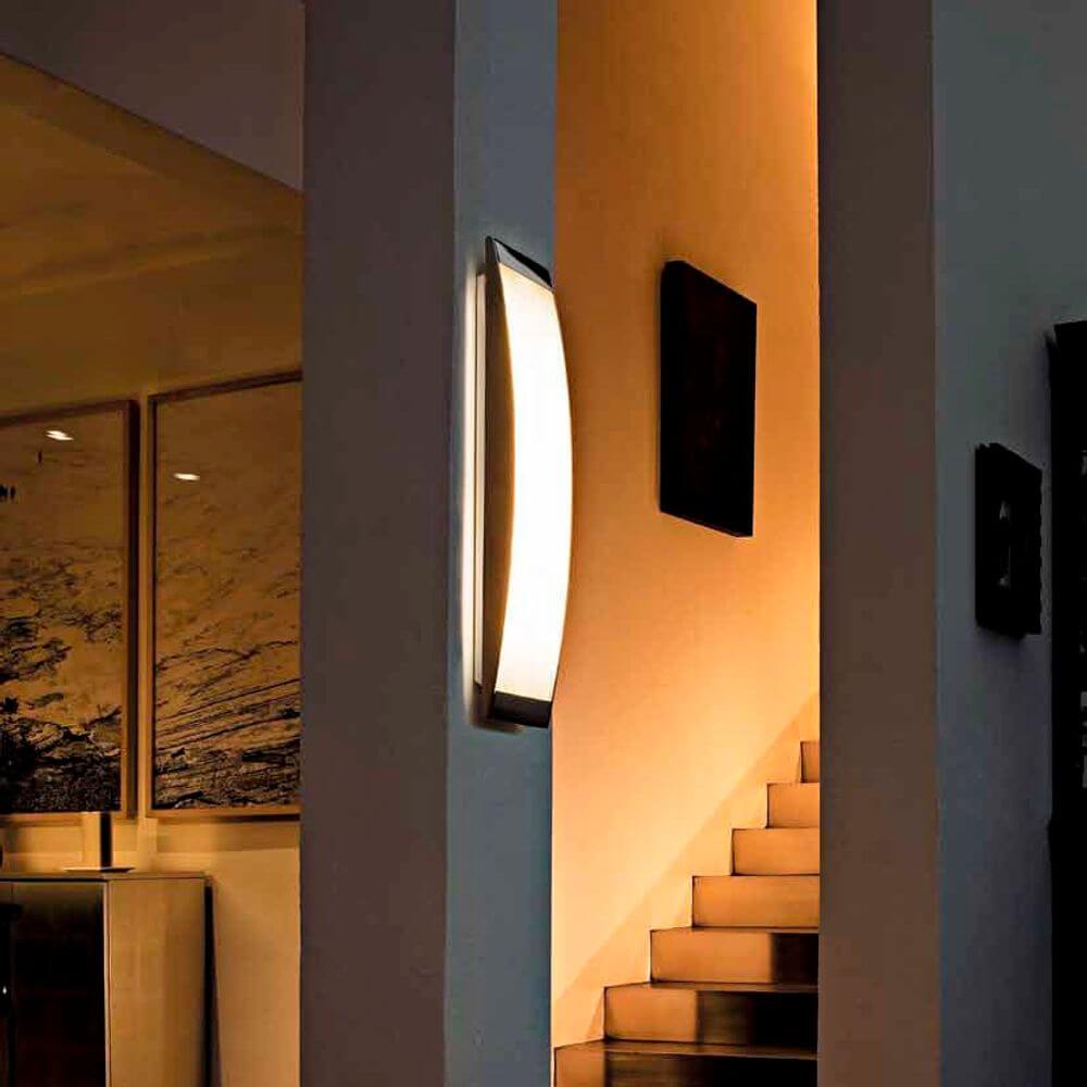 Luceplan Wand- & Deckenleuchte Strip Panel beleuchtet einen modernen Flur mit warmem Licht.