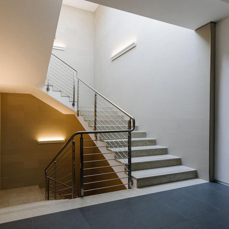 Applique murale Luceplan Any 63 cm blanche dans un éclairage d’escalier moderne, design élégant, agencement modulaire.