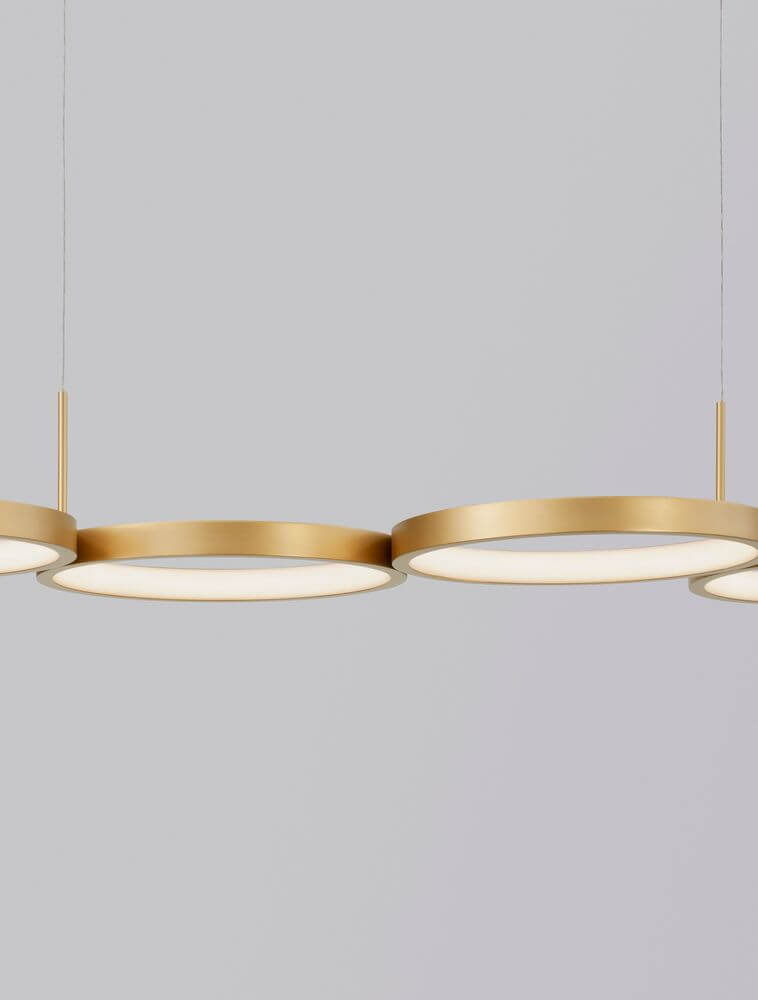 Magnus LED Pendelleuchte 4-flammig 3000K in modernem Design mit goldenen Ringen für stilvolle Beleuchtung.