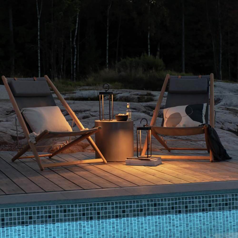 Gemütliche Terrasse mit Manorola LED Außen Laterne CCT, zwei Liegestühlen und Tisch am Pool.