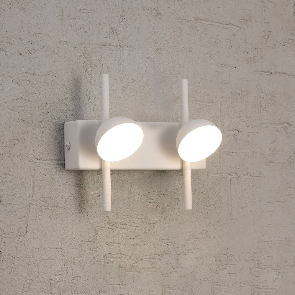 Adn 2-flammige LED-Wandleuchte in elegantem Design an einer Wand montiert.