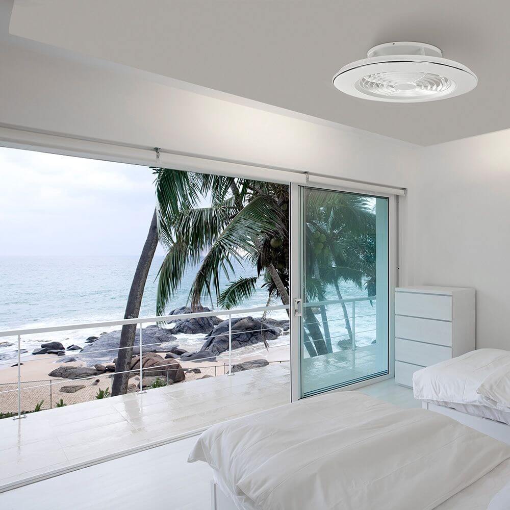 Alisio LED-Deckenleuchte + Ventilator in einem modernen Schlafraum mit Blick auf das Meer.