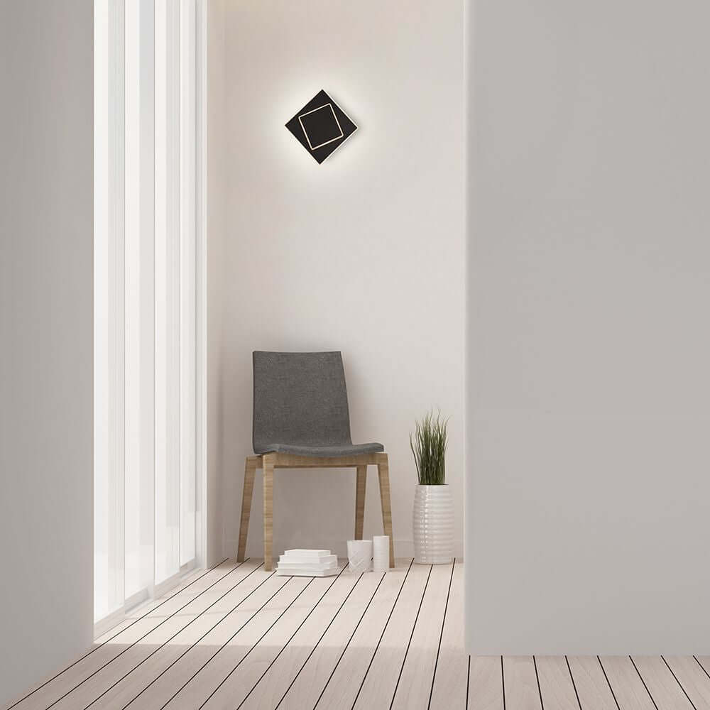 Moderne Dakla LED-Wandlampe klein in eckiger Form, installiert in stilvollem Raum mit Holzfußboden und Stuhl.