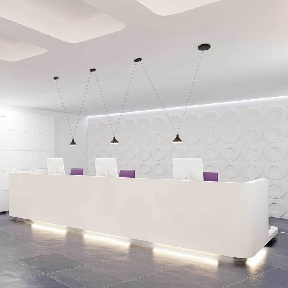 Moderne LED-Hängeleuchte Antares im Empfangsbereich mit weißem counter und stilvollen Akzenten.