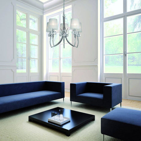 Loewe 5-flammige Pendellampe breit in modernem Wohnzimmer mit blauen Sofas und großen Fenstern.