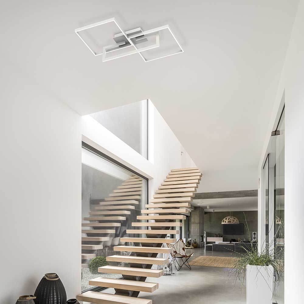 Mural LED-Deckenlampe Weiß-Matt im modernen Wohnraum mit Holztreppe und elegante Lichtwirkung.