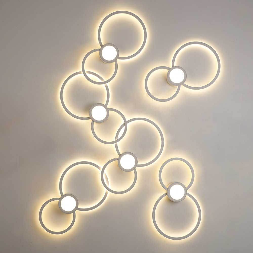 Mural LED-Wandleuchte Weiß in modernem Design mit kreisförmigen Elementen und warmem Licht.