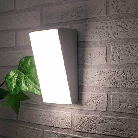 Solden vertikale LED Außenleuchte an einer Wand mit Pflanzen im Vordergrund.