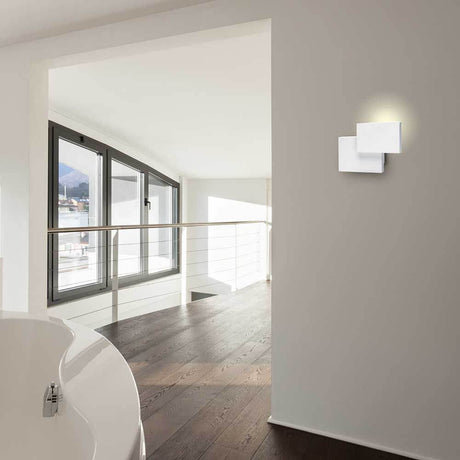 Tahiti White-Matt rectangular LED wall light in a modern living environment with wood flooring and large windows.