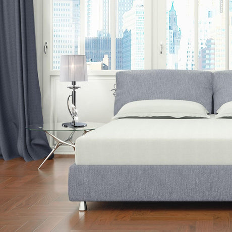 Moderne Schlafzimmeransicht mit Tiffany Tischlampe, Bett und Glasbeistelltisch.