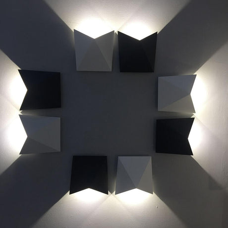 Triax Außen-LED-Wandleuchte an einer Wand, modern und stilvoll, mit geometrischen Formen und Lichtschatten.