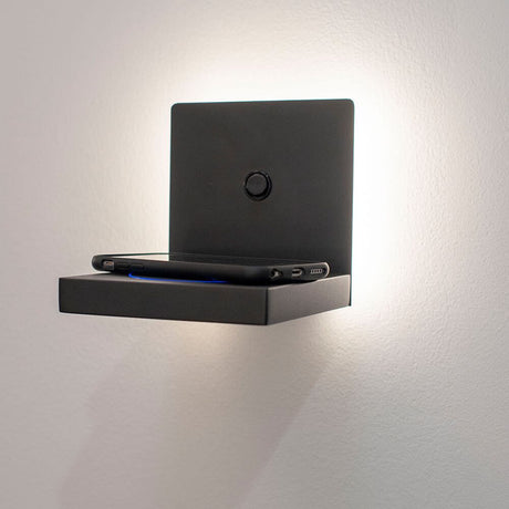 Zanzibar quadratische LED-Wandleuchte mit Ladestation an der Wand, mit Smartphone auf der Ablage.