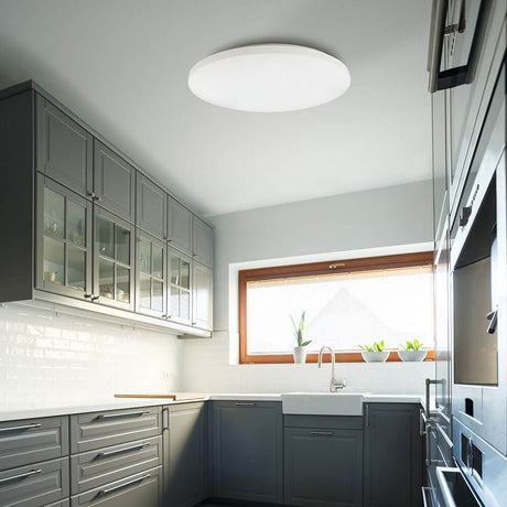 Zero Smart LED-Deckenleuchte Weiß in moderner Küche mit grauen Küchenmöbeln und Fenster.