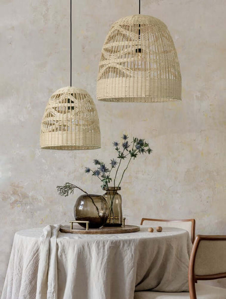 Marlo pendant light bell beige rattan over a set table with vase and flowers.