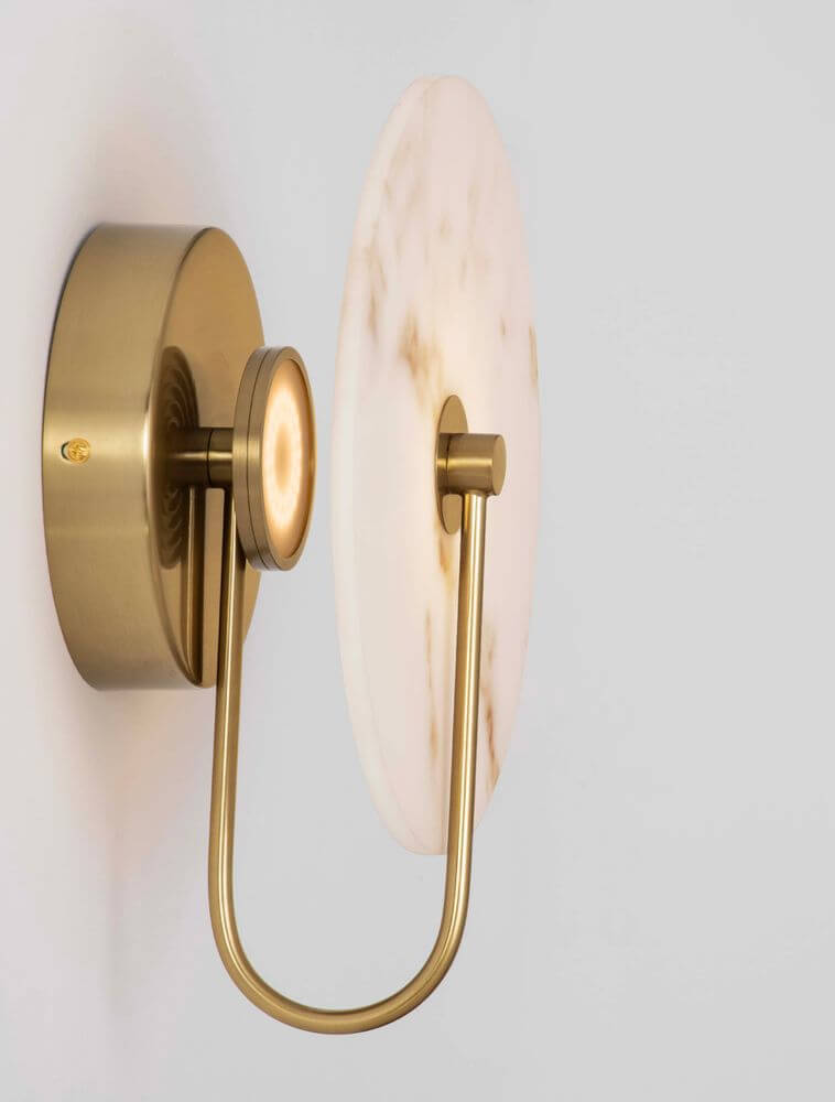Maru Wandleuchte 3000K Gold an der Wand mit eleganter goldener Aufhängung und marmorierter Glasplatte.