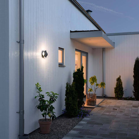 Matera LED outdoor wall light anthracite, opal acrylic glass on a modern house wall at dusk.