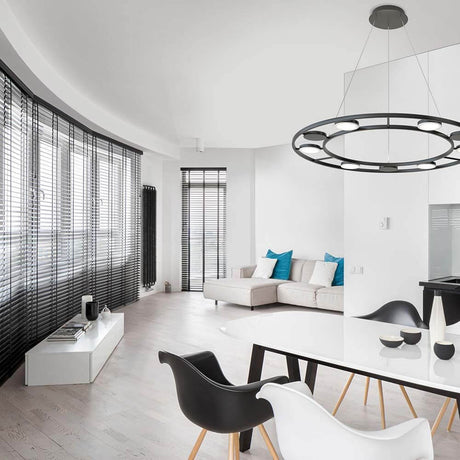 Intetsigende LED Hængelampe Ø 80cm metal i en moderne stue med elegant bord- og stoledesign.