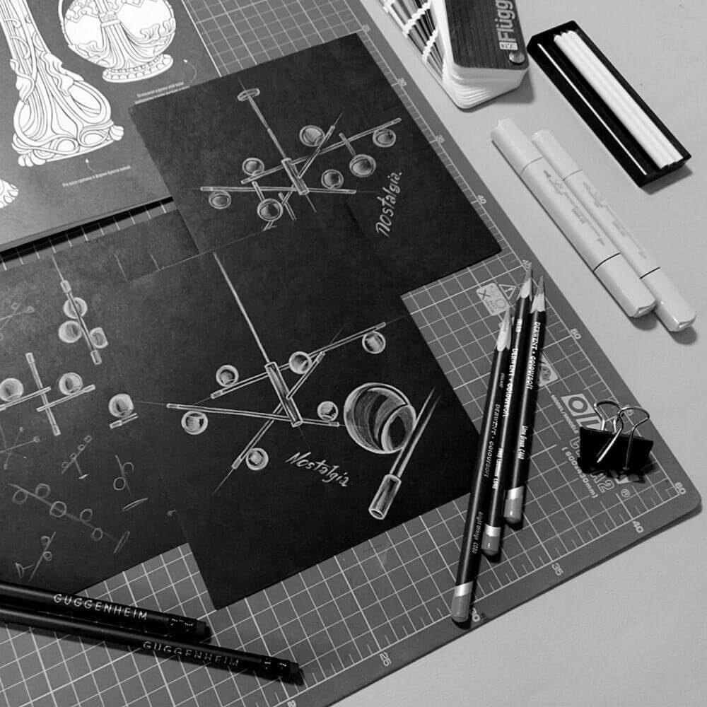 Nostalgia Hängelampe Mini Skizzen auf einem Tisch mit Zeichnungsutensilien und grauem Hintergrund.