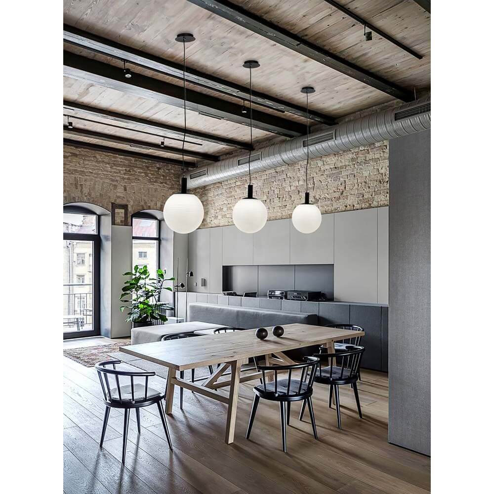 Moderne Perlas Pendellampe aus Glas in klar und weiß, kombiniert mit schwarzem Metall, im stilvollen Essbereich.