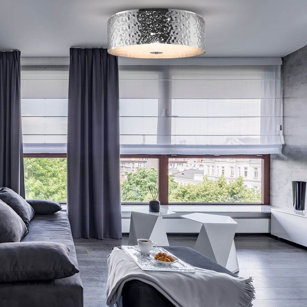 Ripple Deckenleuchte 5-flammig in modernem Wohnzimmer mit grauem Sofa und eleganten Vorhängen.