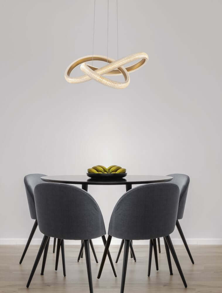 Medora LED Pendelleuchte Ø 52,5cm 3000K Messing-Gold über einem Esszimmertisch mit modernen Stühlen.