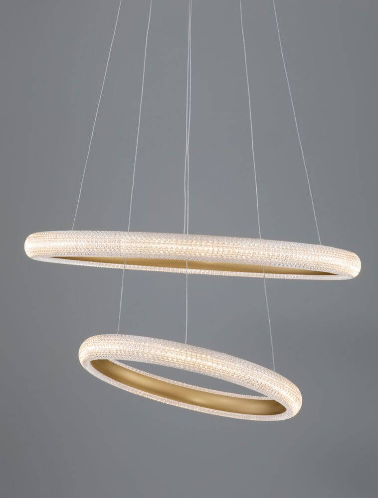Medora LED Pendelleuchte 2-flammig Ø 59cm 3000K Messing-Gold in elegantem Design über einem modernen Esstisch.