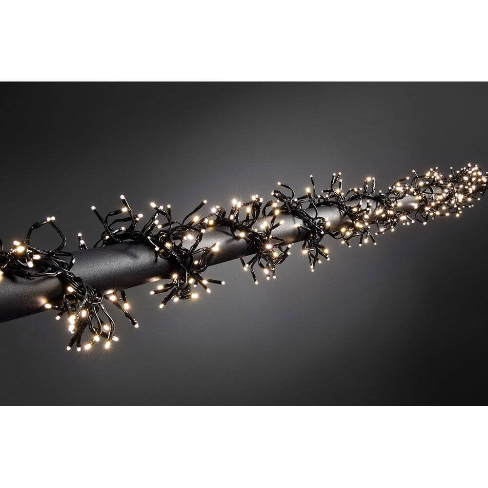 Micro LED Büschelllichterkette Cluster mit 8 Funktionen 1152 Warmweiße Dioden IP44 auf dunkler Oberfläche.