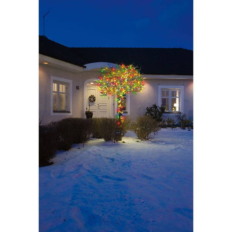 16m Micro LED Lichterkette 80 bunte Dioden IP44, geschmückter Baum vor einem Haus im Schnee.