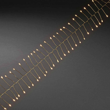 7m Micro LED Lichterkette Firecracker 200 bernsteinfarbene Dioden goldfarbener Draht auf schwarzem Hintergrund.