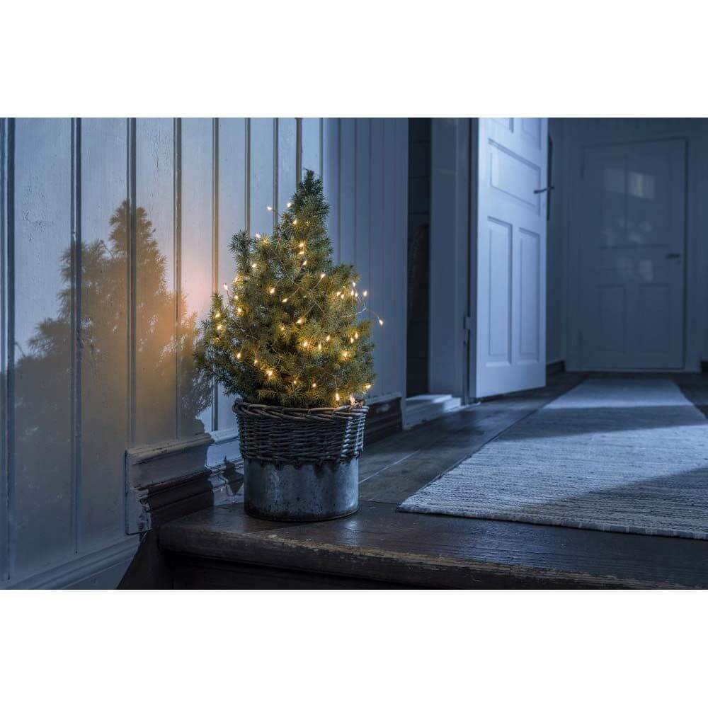 1,5m Micro LED Lichterkette Firecracker mit Timer 60 bernsteinfarbene Dioden batteriebetrieben an einem kleinen Weihnachtsbaum.