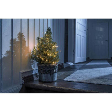 1,5m Micro LED Lichterkette Firecracker mit Timer 60 bernsteinfarbene Dioden batteriebetrieben an einem kleinen Weihnachtsbaum.
