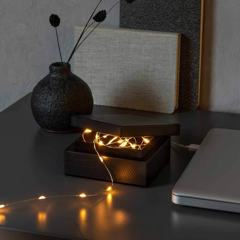 2,5m Micro LED Lichterkette mit USB Anschluss 50 Lichtpunkte in schwarzer Box auf einem Tisch.
