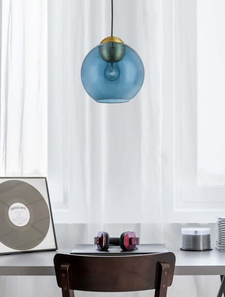 Midori Pendelleuchte E27 Ø 24cm in blauer Glasoptik über einem modernen Schreibtisch mit Schallplatte und Kopfhörern.