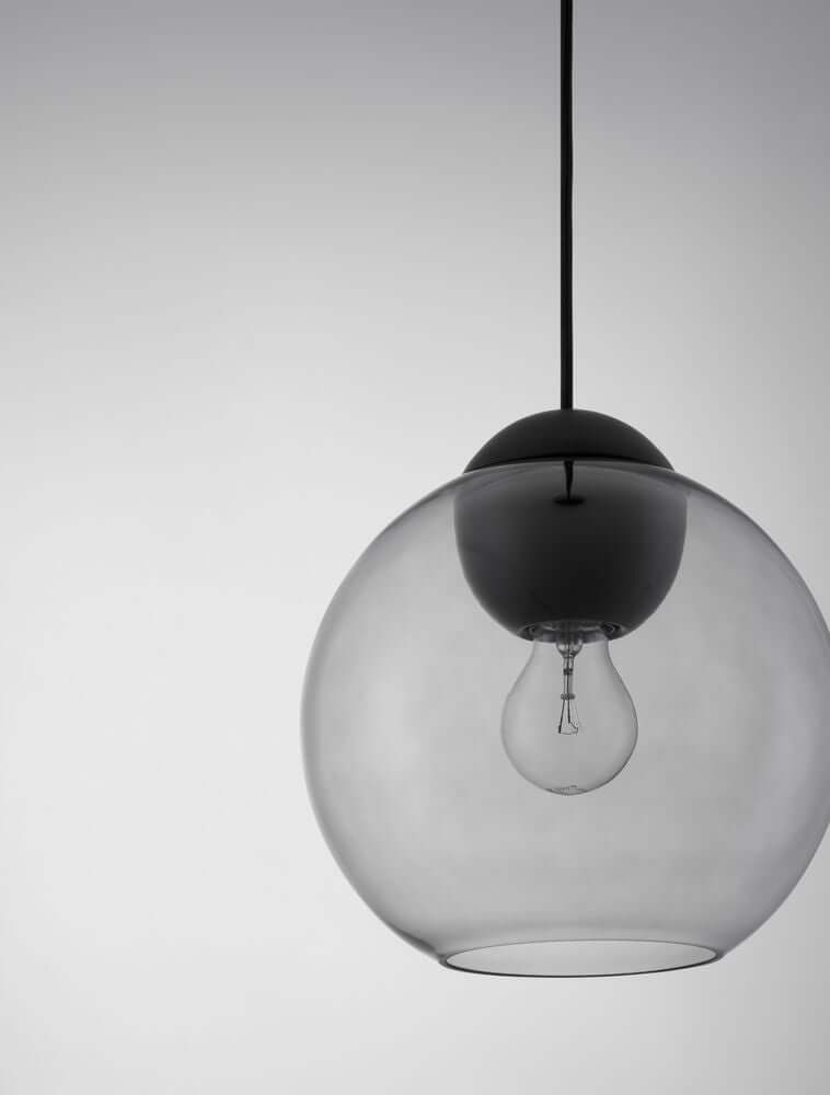 Midori Pendelleuchte E27 Ø 24cm mit mattem schwarzen Metallkopf und rauchgrauem Glasschirm.