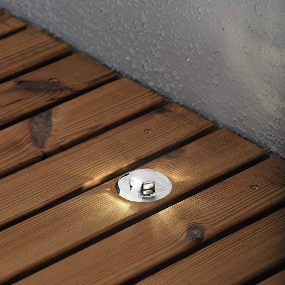 Mini Bodeneinbaustrahler aus dem 3er-Set auf einem Holzboden, ideal für stimmungsvolle Beleuchtung.