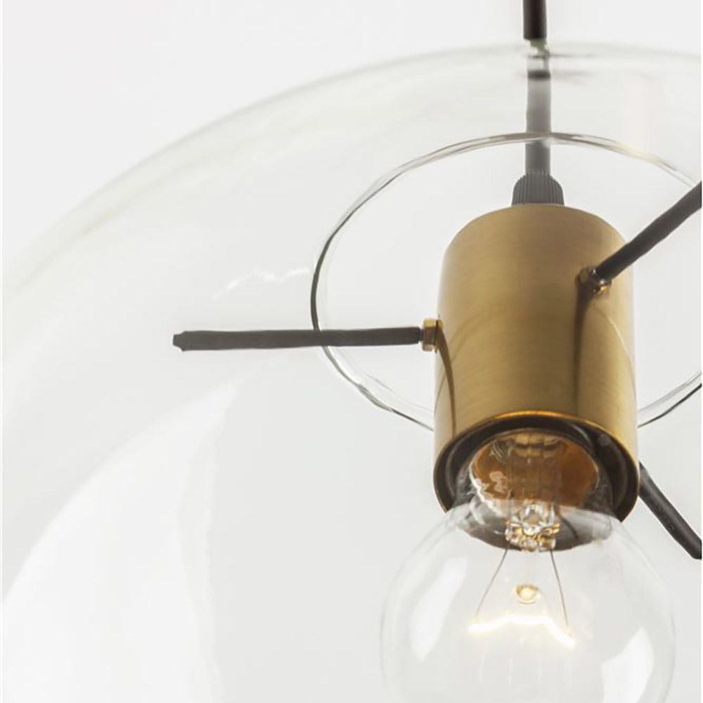 Detailaufnahme der Mirale Kugel-Hängelampe aus Glas mit goldener Fassung und schwarzem Gestell.