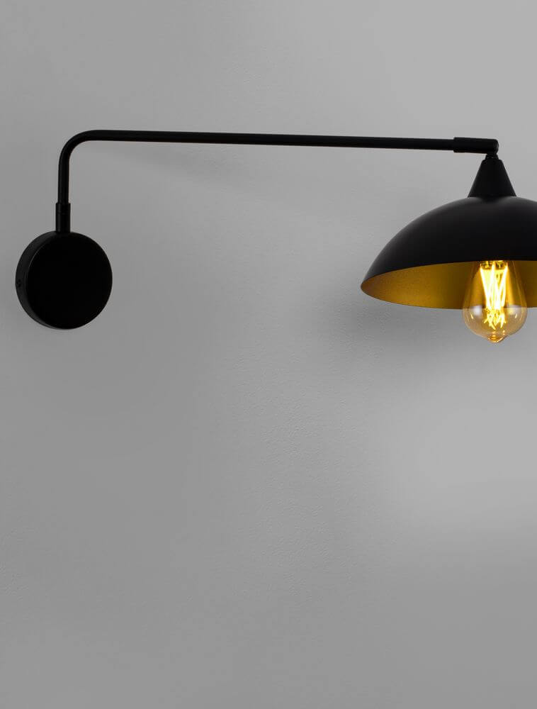 MIRBA Wandleuchte Schwarz, Gold mit schwarzem Metallarm und goldfarbenem Innenleben.