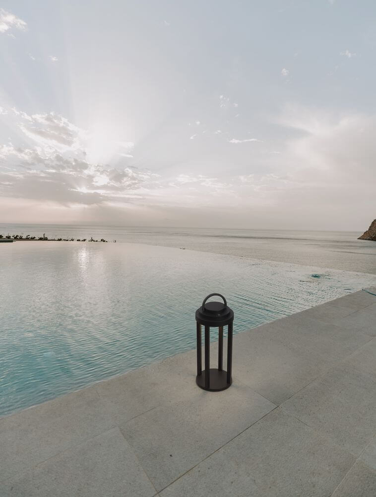 Mocha LED Außenstehleuchte 3000K Anthrazit IP65 neben einem Pool bei Sonnenuntergang