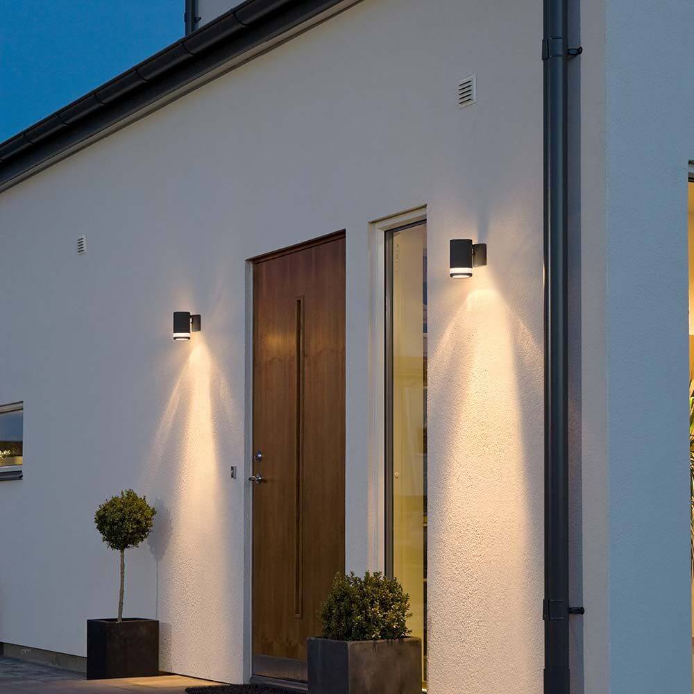 Modena Außen-Wandlampe Schwarz mit Reflektor an Hauswand, elegantes Design und optimale Beleuchtung.