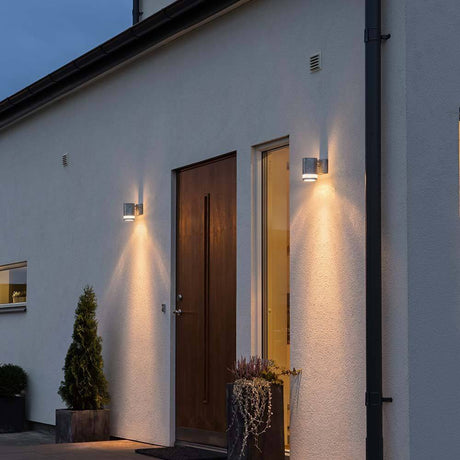 Modena reflector outdoor wall light steel, clear acrylic glass mounted on a modern house wall with front door.