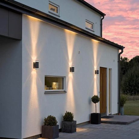 Modena applique da esterno con fascio di luce nera su una parete moderna al tramonto.