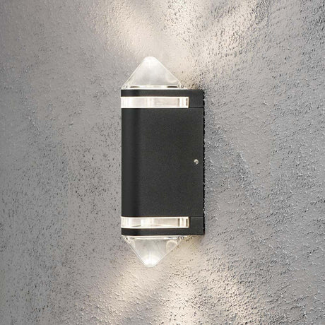 Modena Außen-Wandleuchte mit doppeltem Lichtkegel Schwarz an einer grauen Wand montiert.