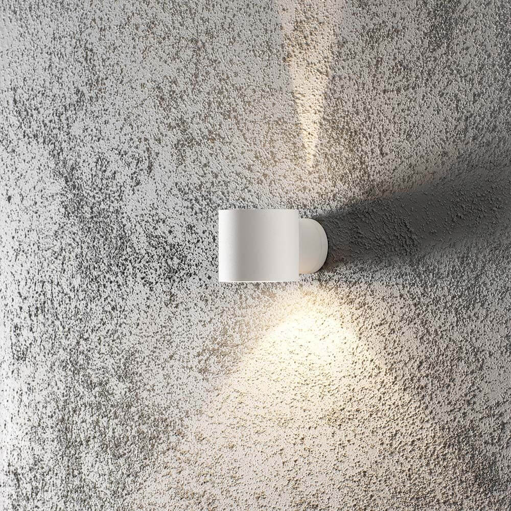 Modena Square Außen-Wandleuchte Weiß, klares Glas an einer strukturierten Wand im Lichtschein.