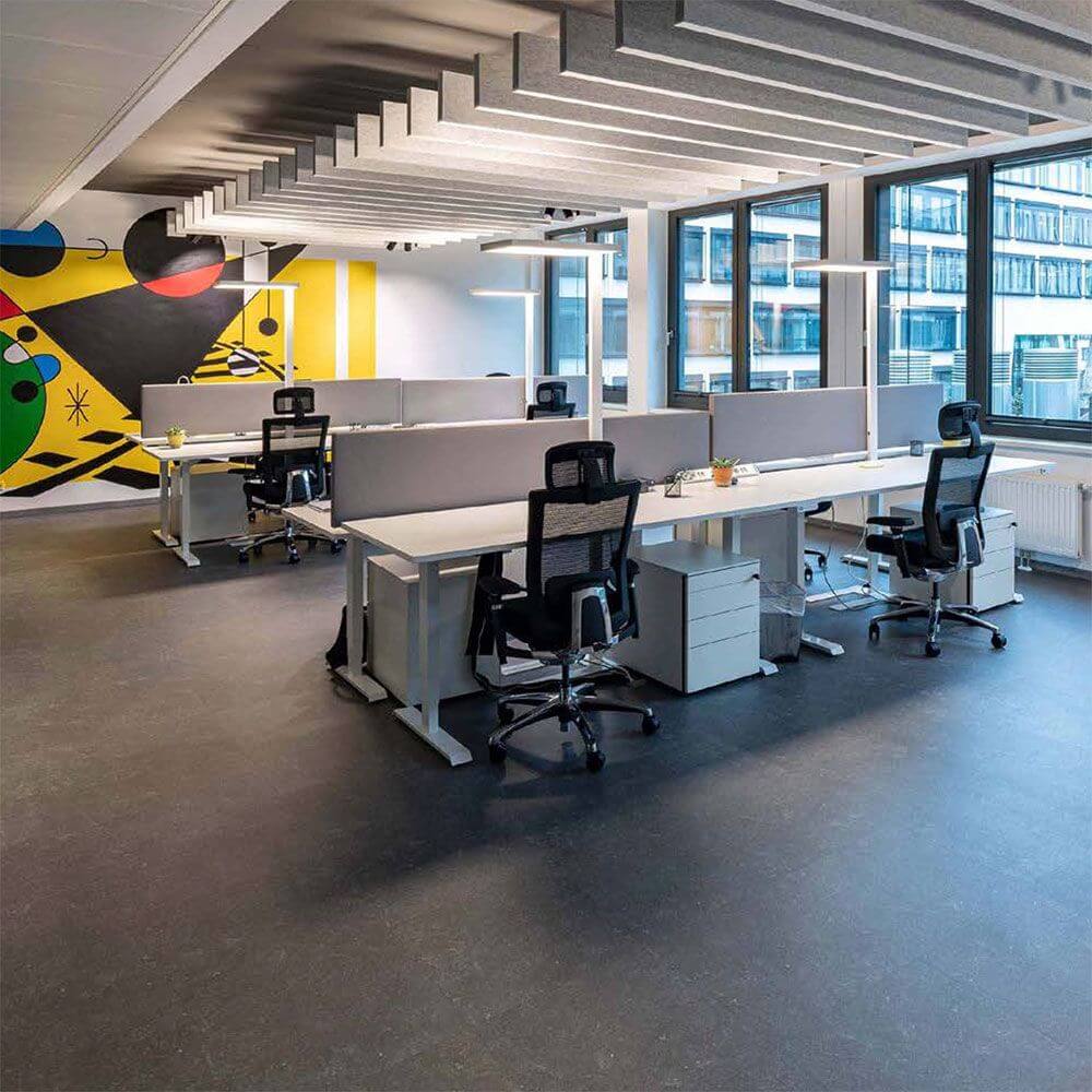 Modernes Büro mit Schreibtischen, ergonomischen Stühlen und stylischem Wanddesign in lebhaften Farben.
