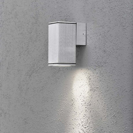 Monza outdoor wall light, clear glass, reflector installed on a wall, radiant light directed downward.