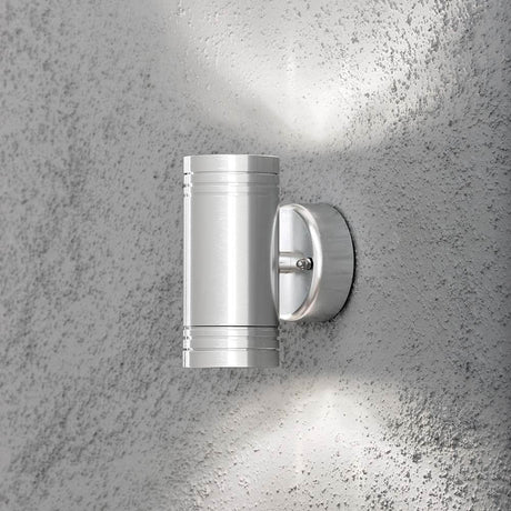 Monza LED lampada da parete esterna con doppio fascio di luce, design elegante su un muro ruvido.