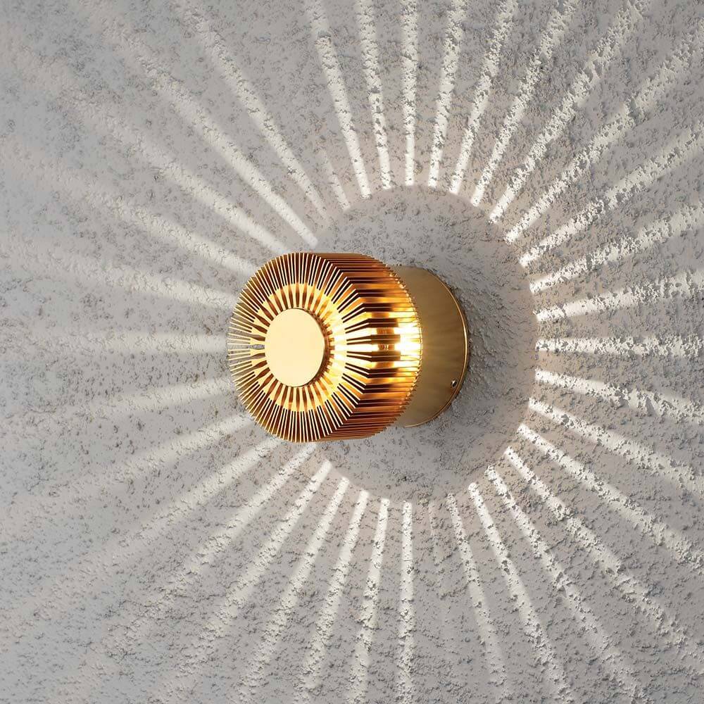 Monza LED Effekt Außen-Wandleuchte Bronzefarben an einer Wand mit strahlendem Lichtmuster.